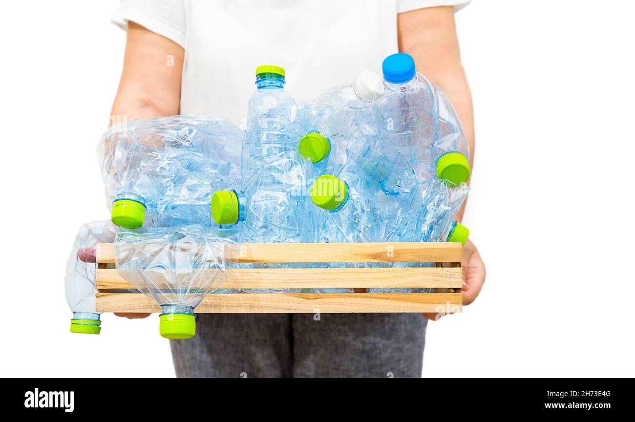 Woman holding a wooden box with blue plastic bottles isolated on white background. Recycling Stock Photo
