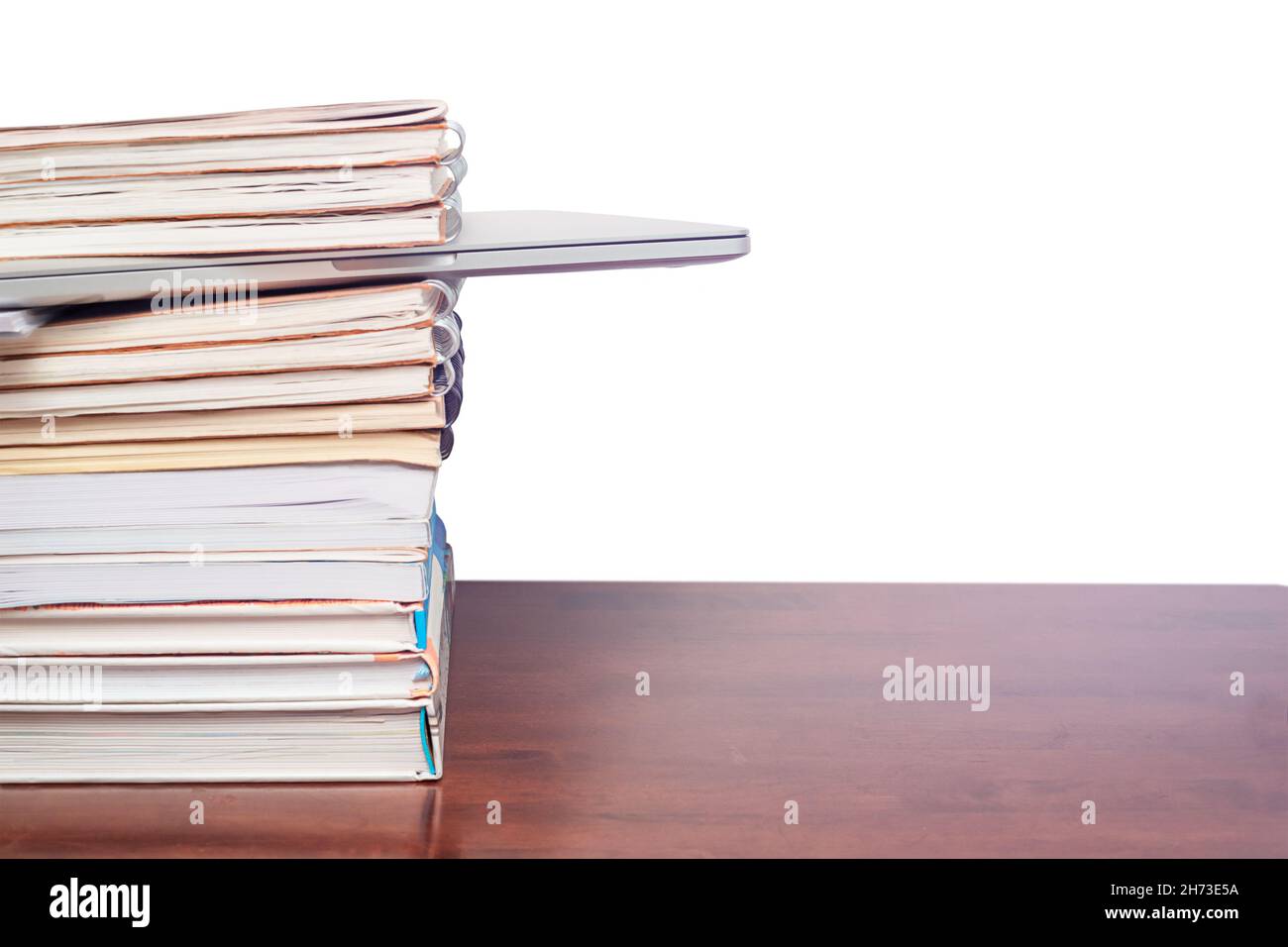 Laptop in a stack of books isolated on white background Stock Photo