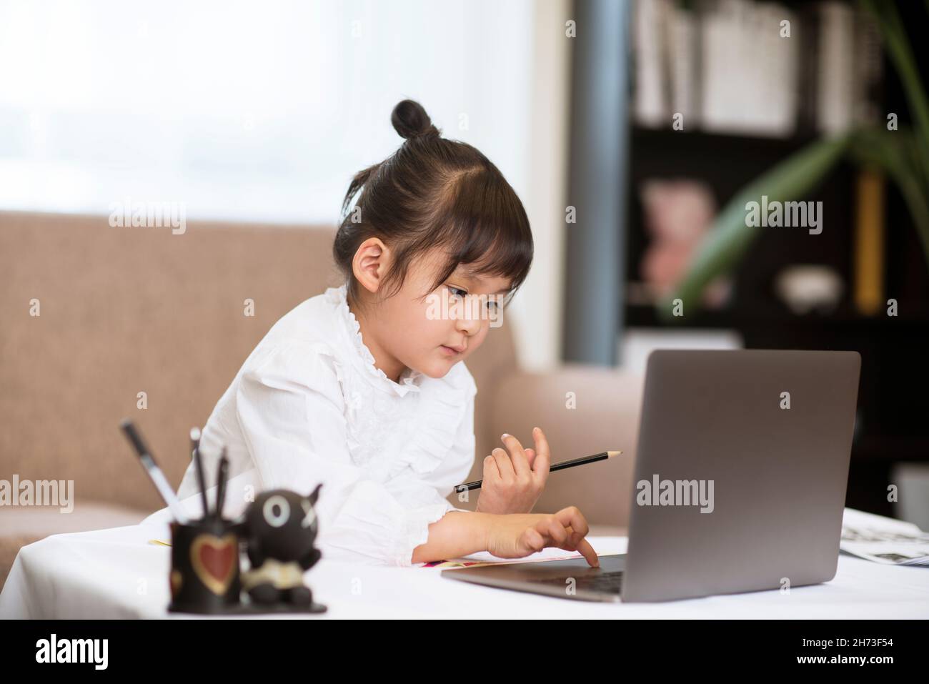 Little cute girl learning online Stock Photo
