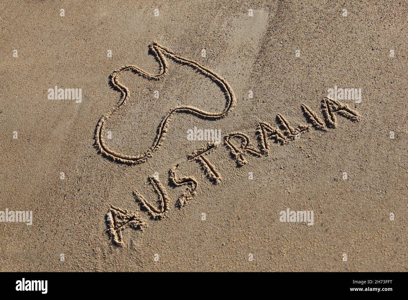 Australia Map and word drawn in the sand at the beach on an angle.  Australia's beaches are one of its iconic drawcards. Stock Photo