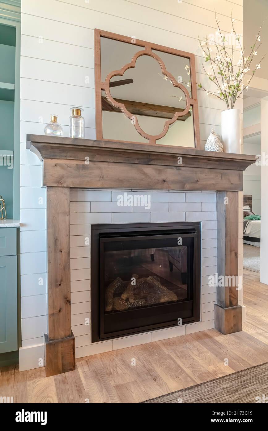 Fireplace with wood frame and decorative mirror against living room accent  wall Stock Photo - Alamy