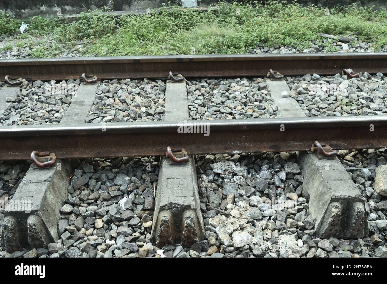 Railway in Thailand, Metal rails on concrete blocks and piles of stones, Old-style rail transport Stock Photo