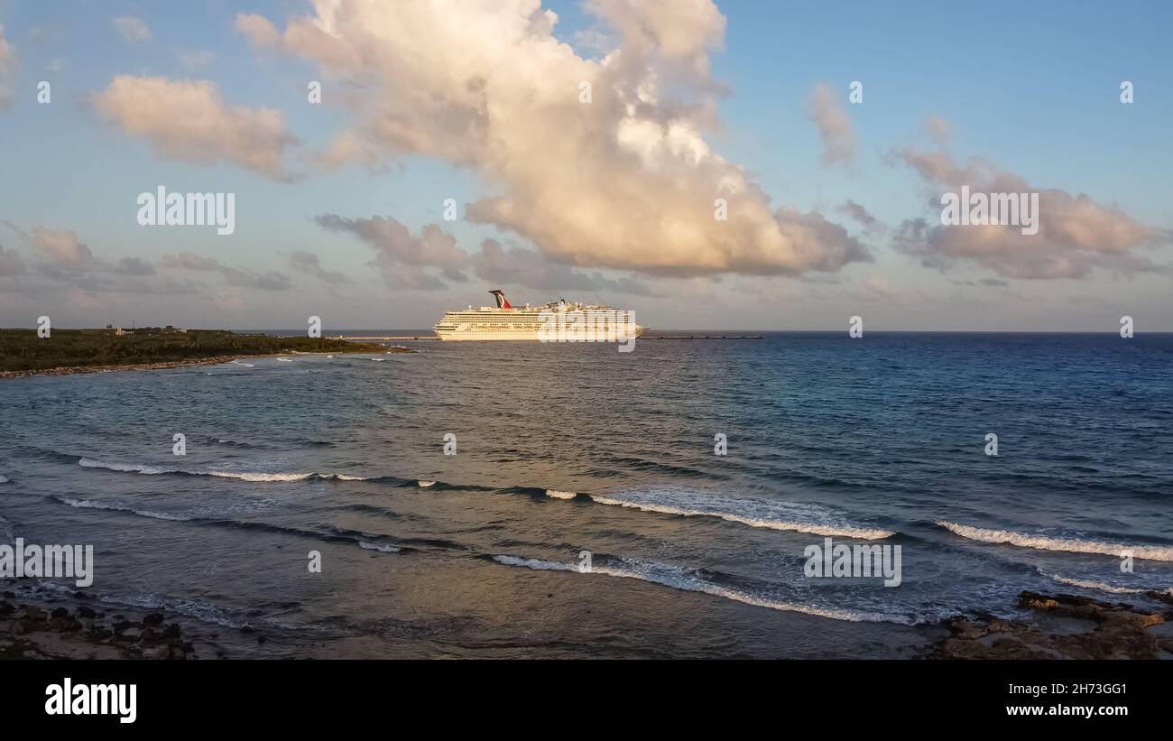 Cozumel, Mexico - February 11, 2020: High angle aerial shot of Carnival Freedom docked in Costa Maya port. Shore line, splashing waves in the foregrou Stock Photo
