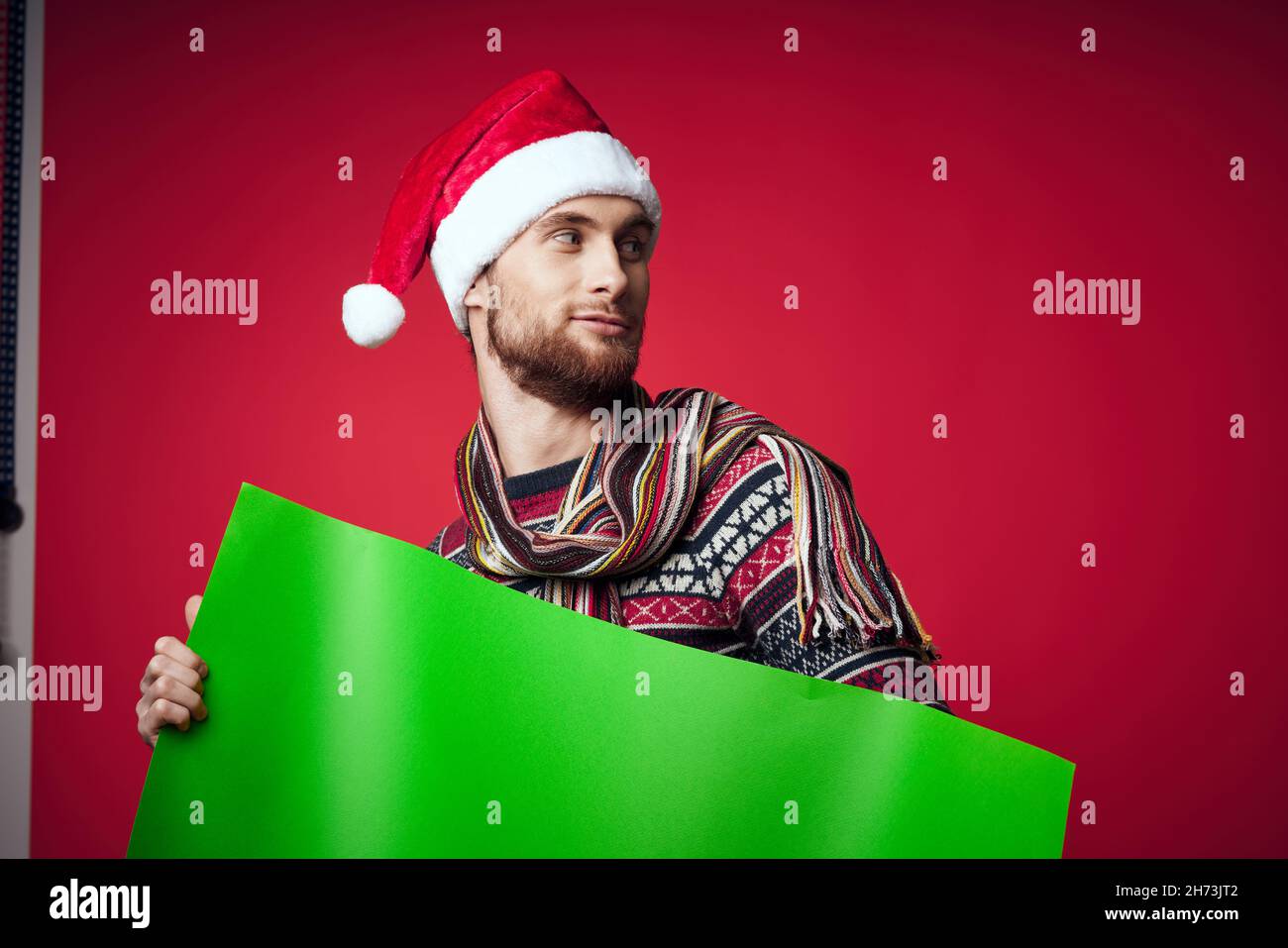 handsome man in a santa hat holding a banner holiday red background ...