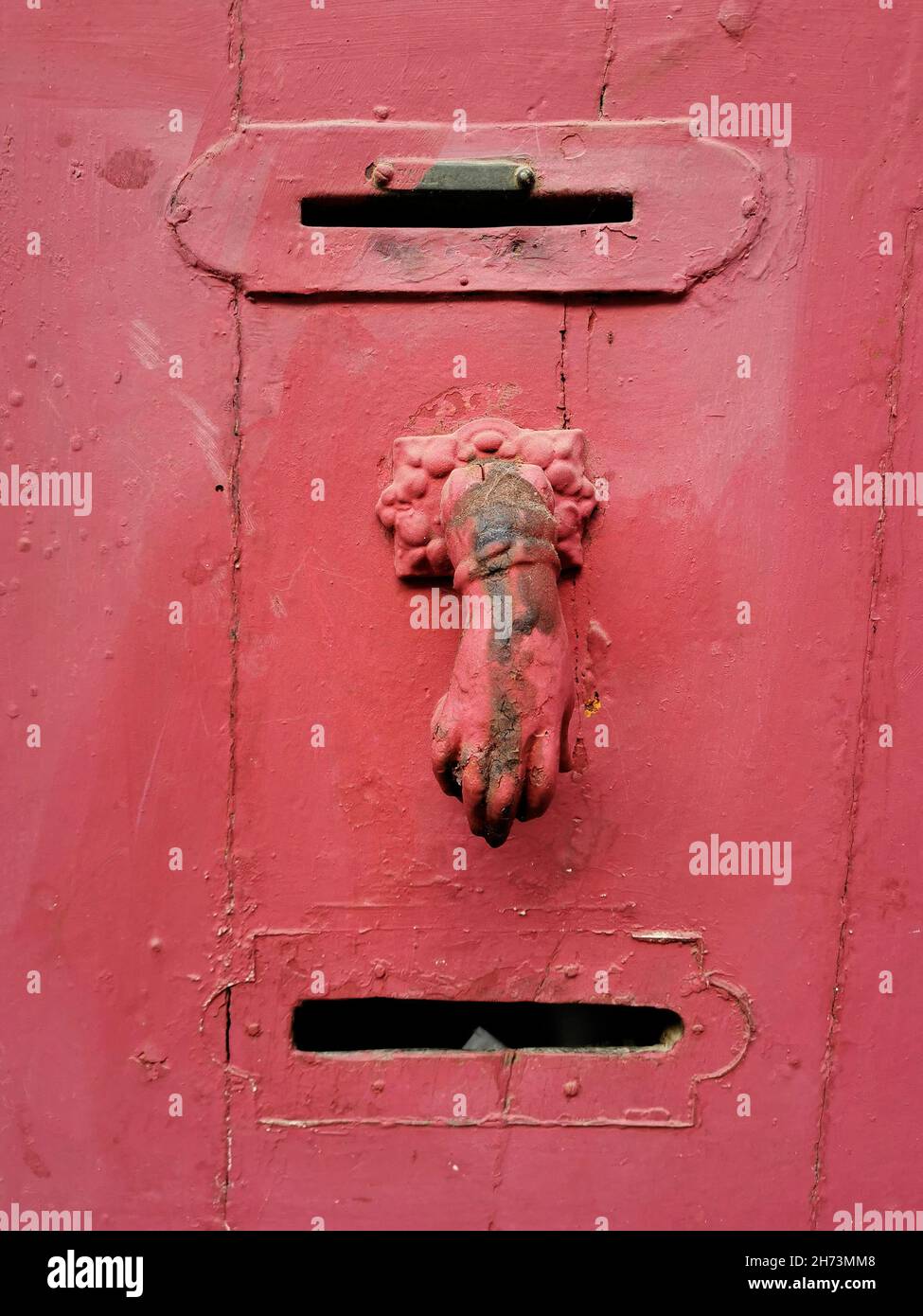 A vertical closeup shot of an old rusty door holder with a peeled paint Stock Photo