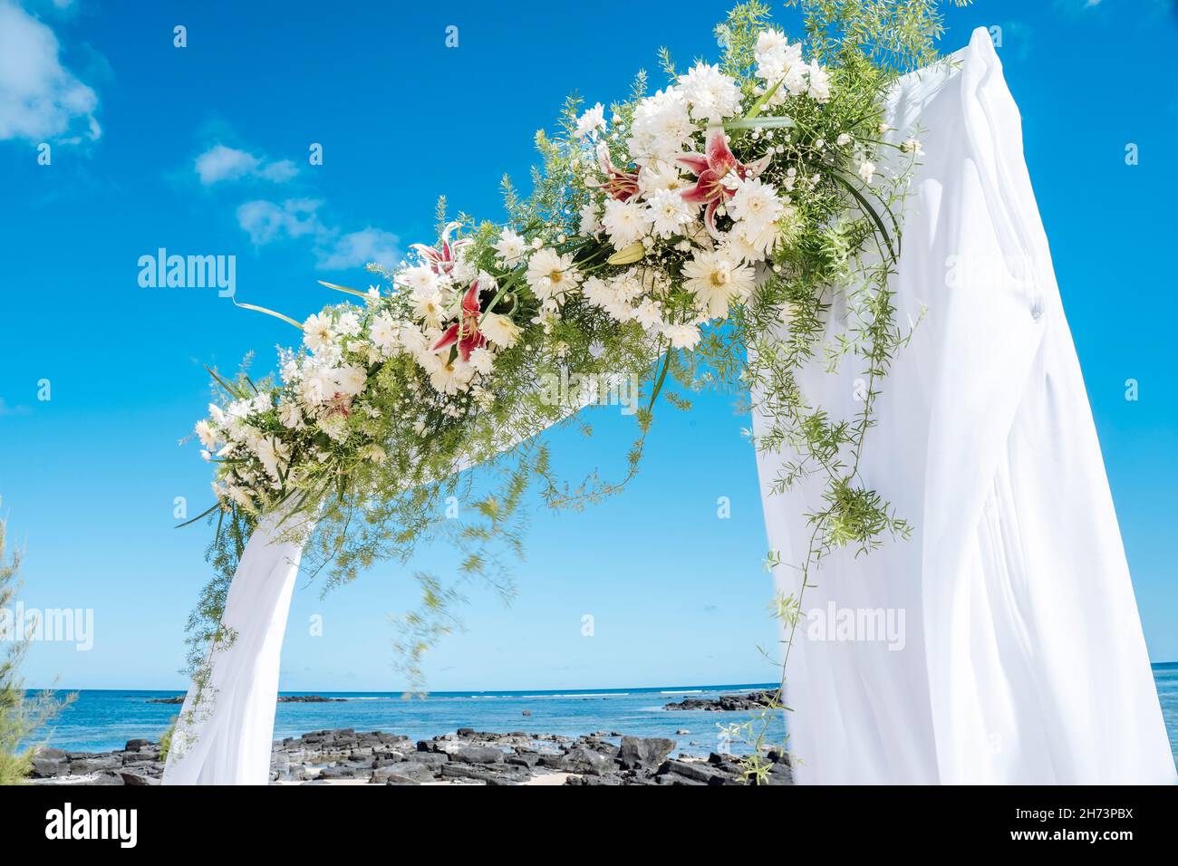 Wedding arch of flowers on the sky background, wedding ceremony of a
