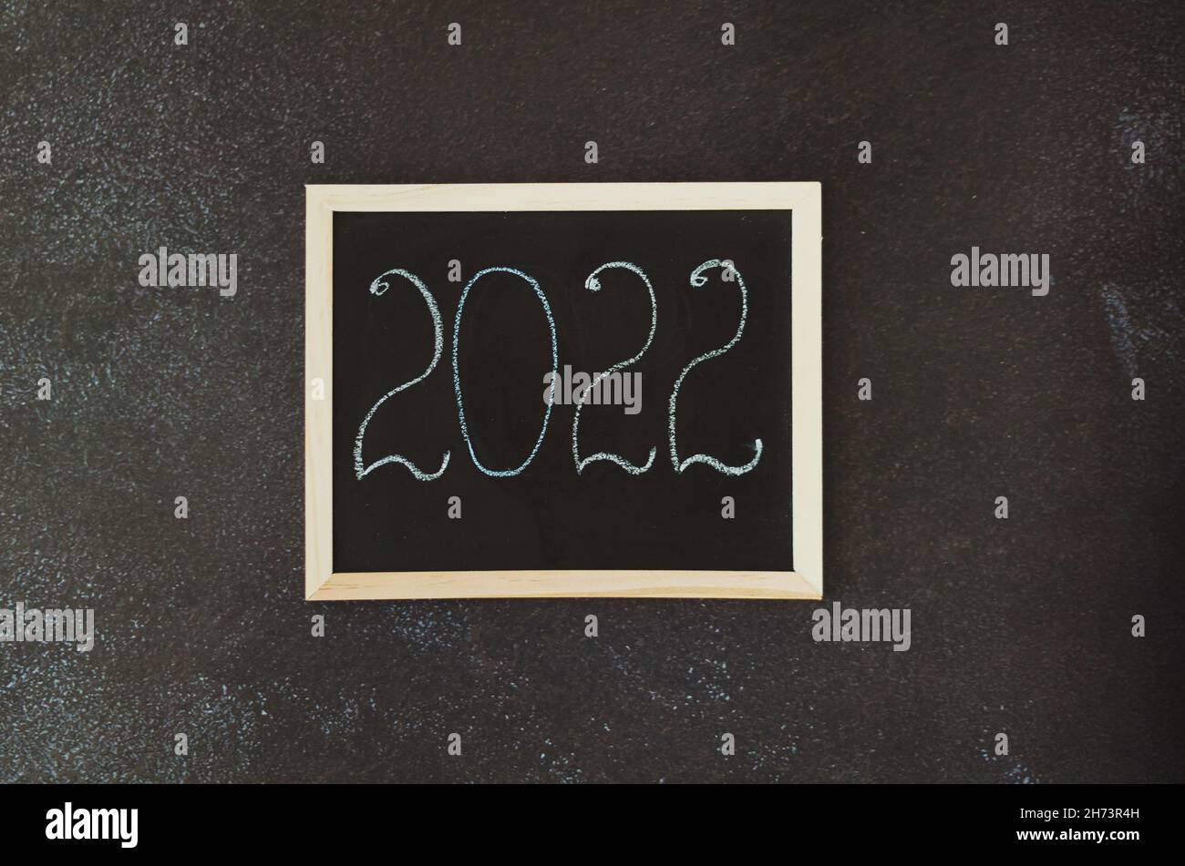 Christmas, New Year flat lay on black background. Christmas decorations with cup of hot coffee. Numbers 2022 on a writing board. Cacti. Top view Stock Photo