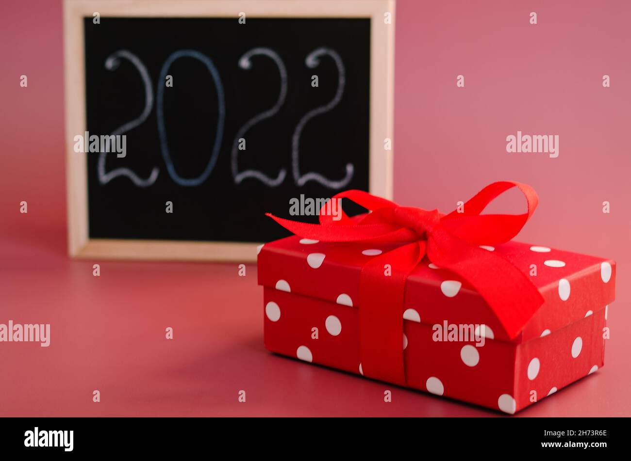 Christmas flat lay on red background with place for text. Christmas hat, toy tree, shopping trolley and a writing board. Resolutions, shopping, plan Stock Photo