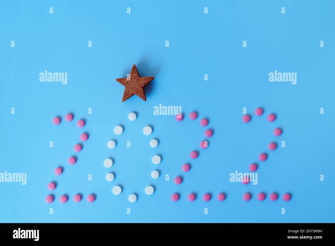 Christmas, New Year flat lay on blue background with place for text. numbers 2022 making with pills and medical mask. Top view. Copy space. Mock up. Stock Photo