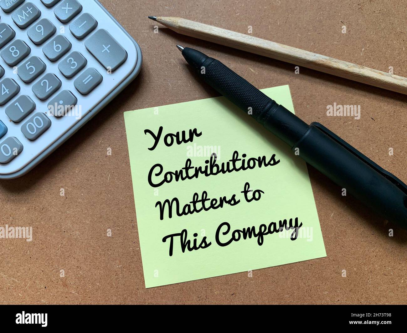 Text on sticky note with calculator, pen and pencil - Your Contributions Matters to This Company Stock Photo