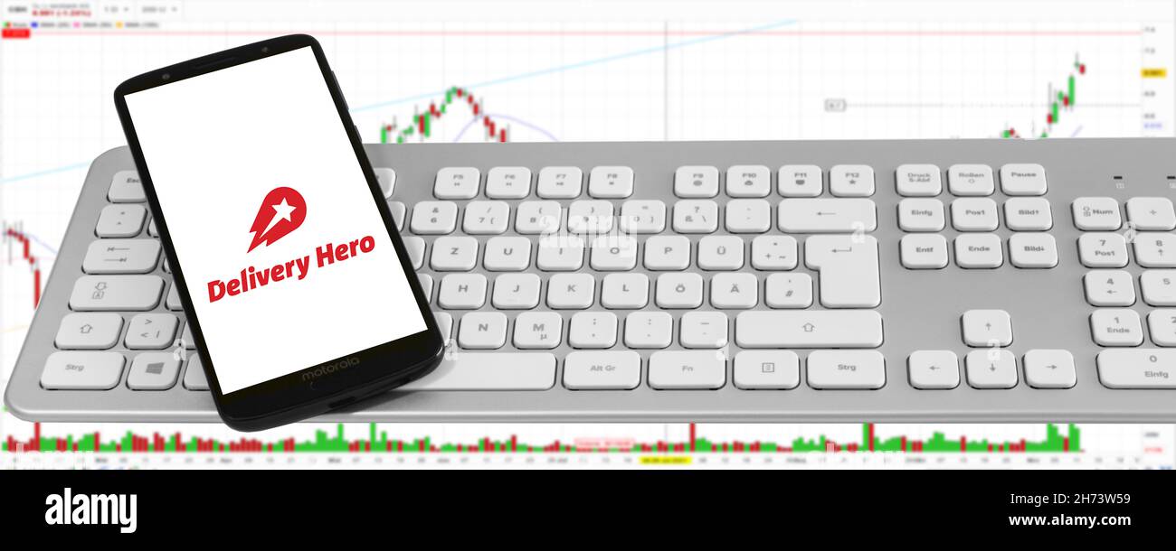 Hamburg, Germany - November 14  2021: Delivery Hero Lieferservice  mit Logo Smartphone Tastatur Aktienmarkt Diagramm Hintergund Banner Stock Photo