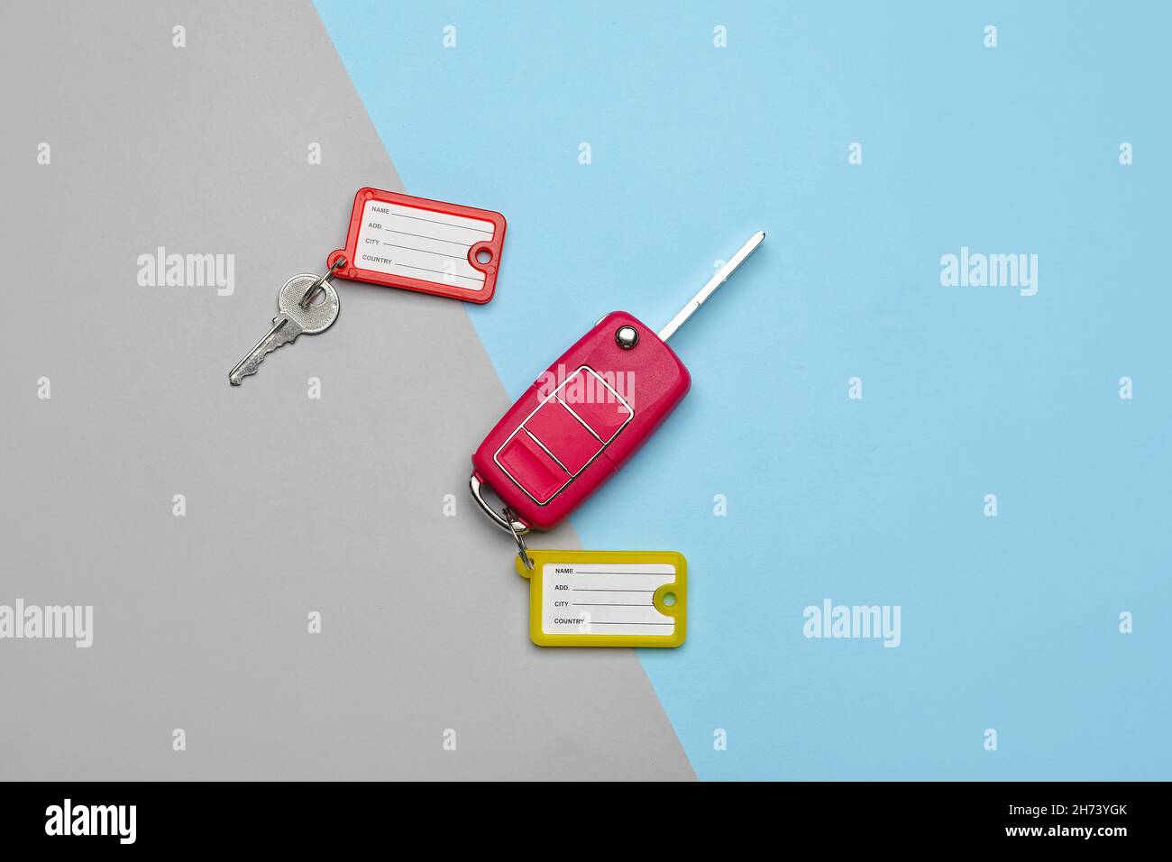 Keys with plastic tags on blue and grey background, top view Stock Photo