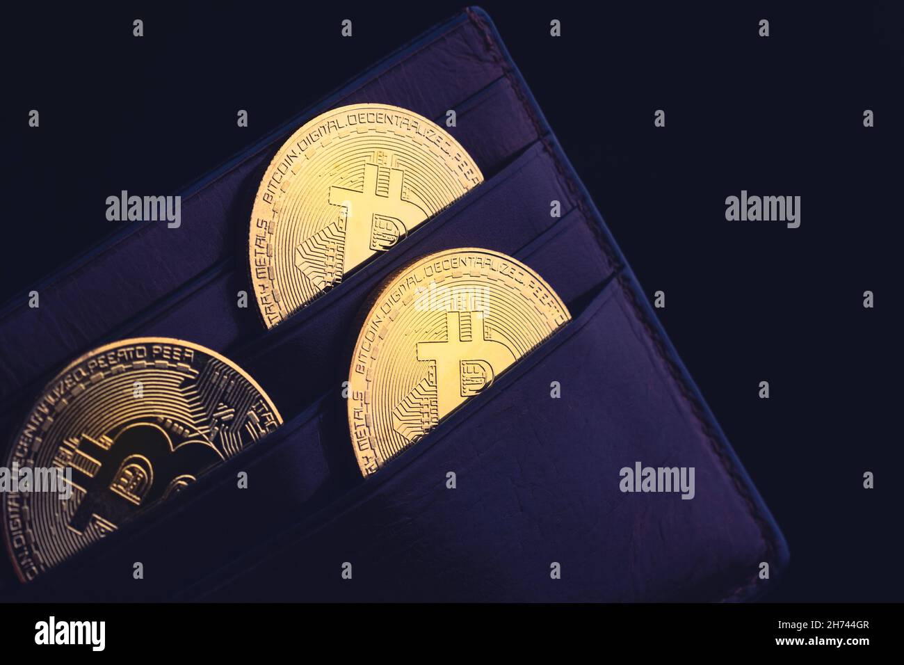 side view closeup concept of bitcoin cryptocurrency golden coins in leather black money wallet Stock Photo