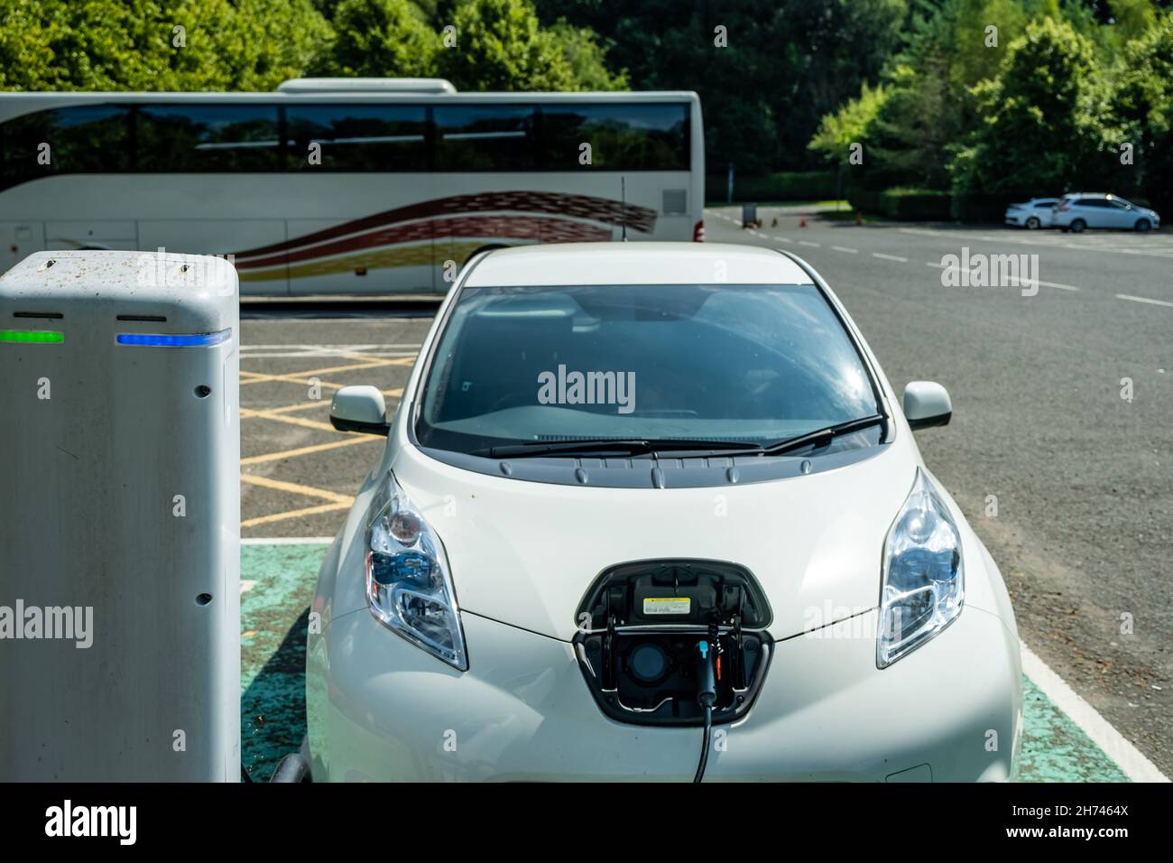 An electric vehicle charging while being parked at a car park in