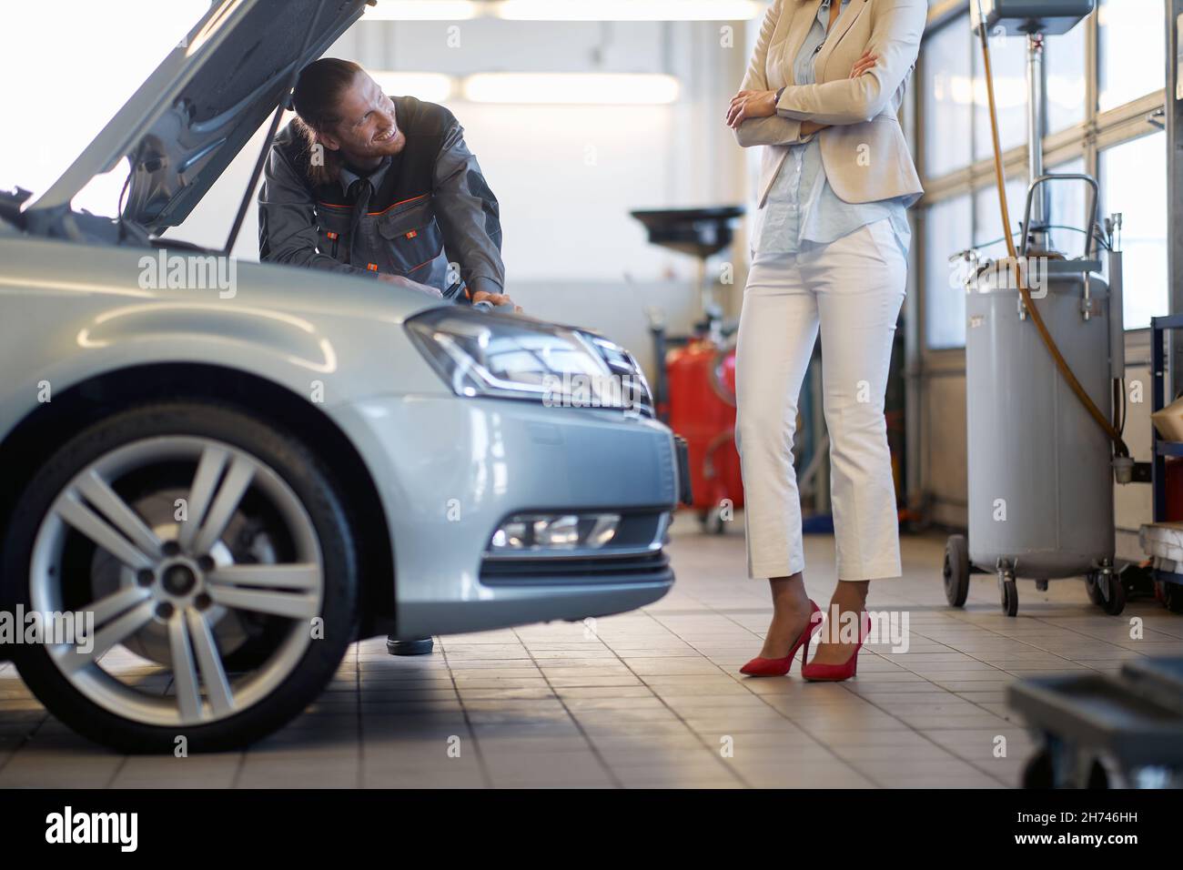 man mechanic communicates with the smiling woman client Stock Photo