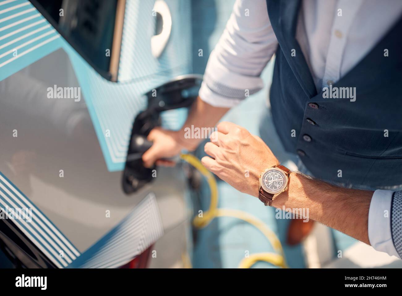 Fast charging of an electric car.Modern man charging his electric car. Stock Photo