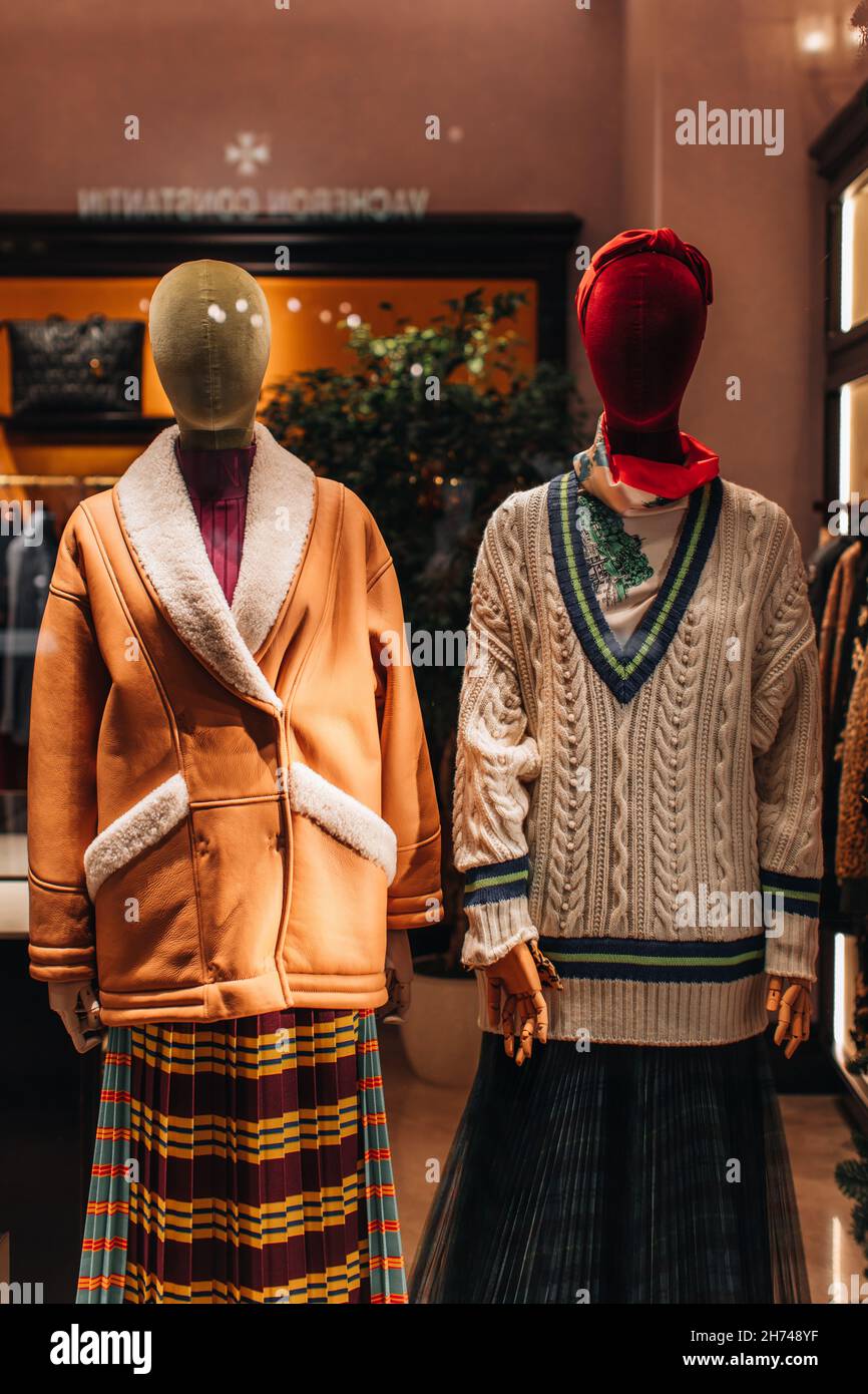 Mannequins in a shop window dressed in a stylish fashionable winter collection. Knit Sweater and Brown Fur Coat Stock Photo