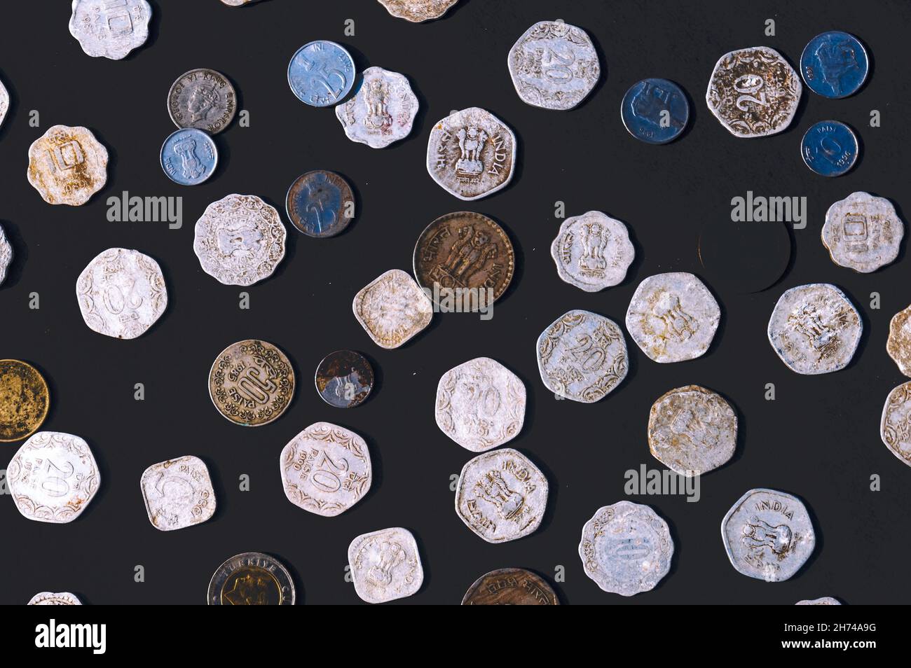 Mix of old antique obsolete Indian Rupee Coin currency on rustic floor. Full Frame. Table Top View. Close Up Stock Photo