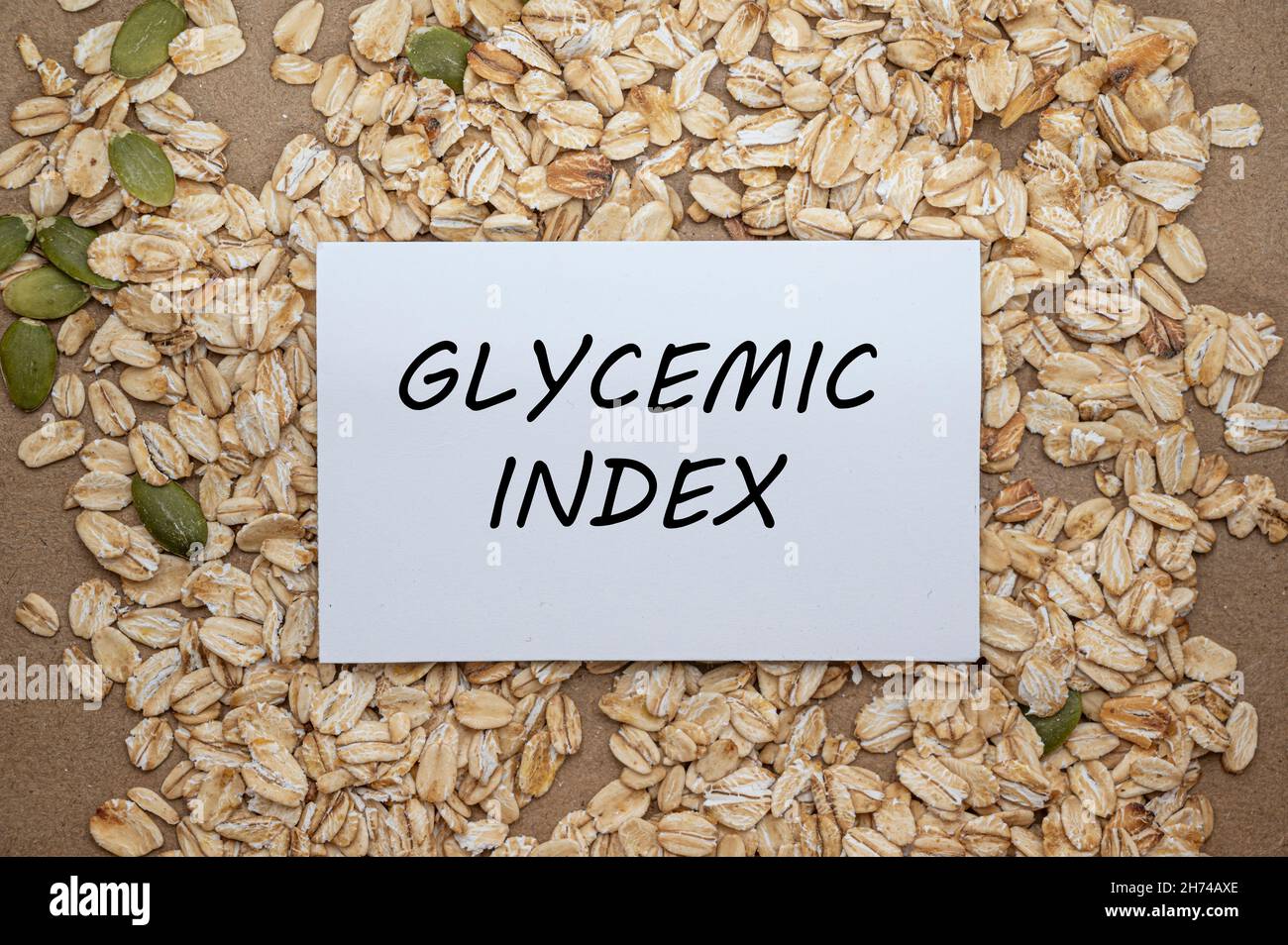Top view of card with text Glycemic index on oat and seeds background. Healthy eating concept. Stock Photo