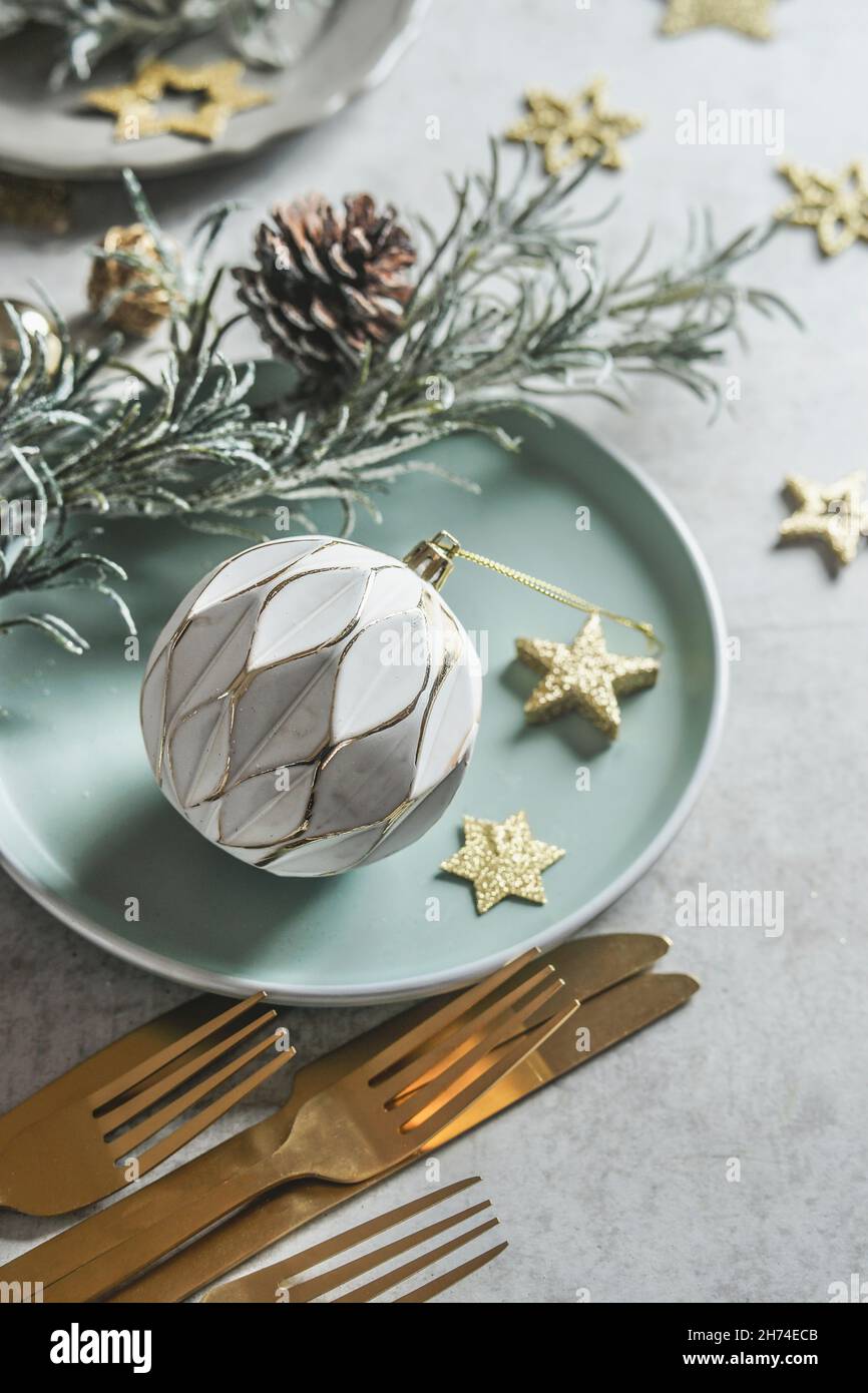 Christmas table setting with white vintage bauble, golden decoration ...