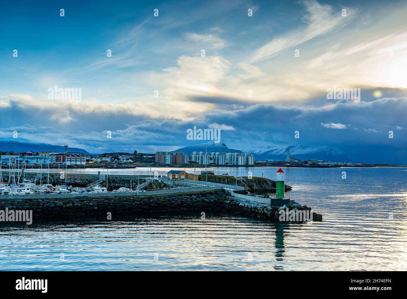 Leuchtfeuer vor Bodø in Norwegen. Herbst, Wetter mit blauem Himmel und Wolken einer Sturmfront. Farbige, neue Wohnblocks am Ufer und Jachthafen Stock Photo