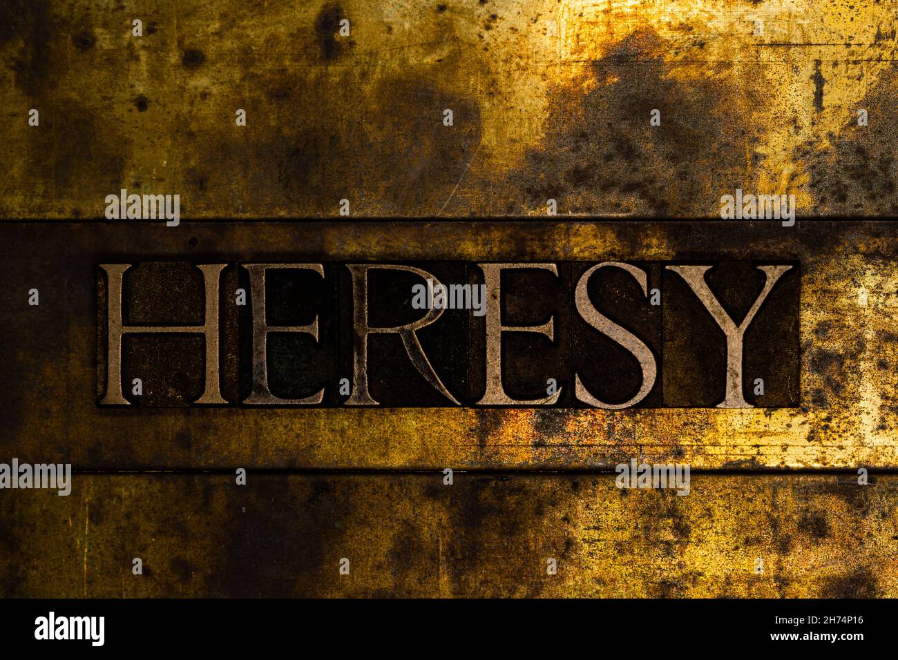 Heresy text message on textured grunge copper and vintage gold background Stock Photo