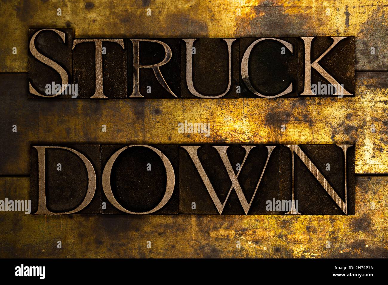 Struck Down text message on textured grunge copper and vintage gold background Stock Photo