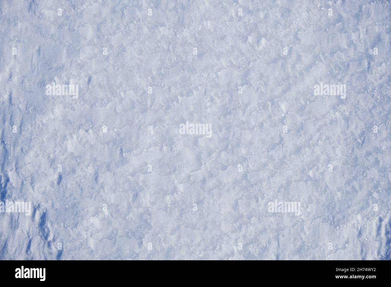 Texture of winter snow surface. Blue natural snow background with drawings made by the wind. Stock Photo