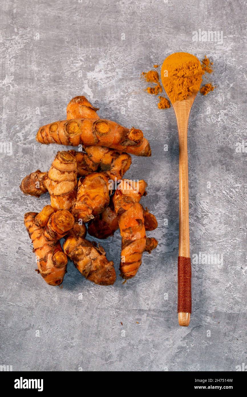 Ground Turmeric and Root Turmeric Arranged on a Grey Background Stock ...