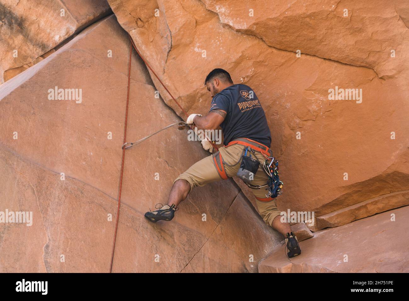 A climber on the difficult Bad Moki Roof route in the Wall Street climbing area, Moab, Utah. Stock Photo