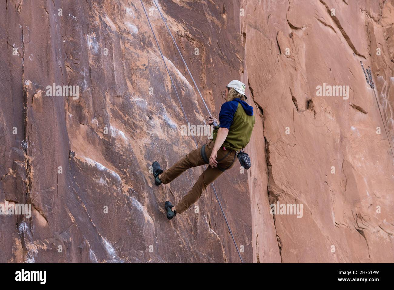 A sport climber rapels down the Nervous in Suburbia route in the Wall Street climbing area by Moab, Utah. Stock Photo