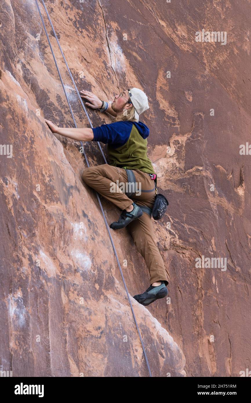 A sport climber on the Nervous in Suburbia route in the Wall Street climbing area by Moab, Utah. Stock Photo