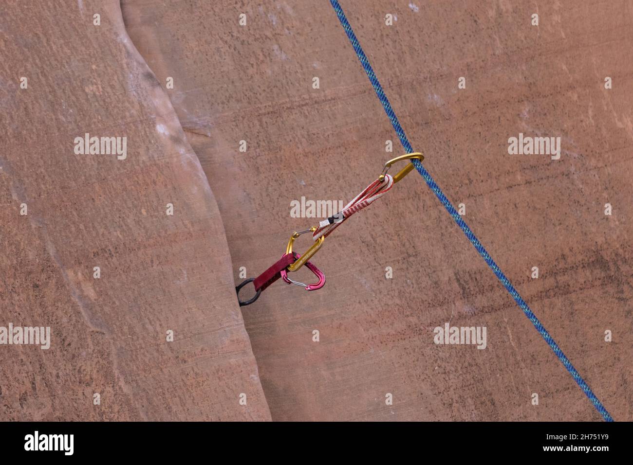 The climbing rope running through a quick draw in a crack on a climbing