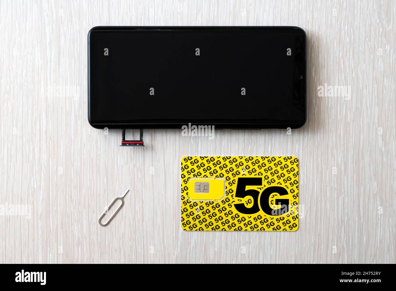 Replacing a 4G SIM card with a high speed 5g SIM card close up on the store's wooden table Stock Photo