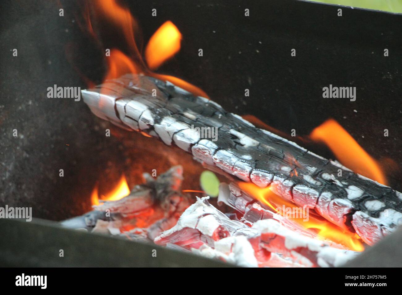Smoldering ashes of a bonfire. Fire burns closeup at campfire Stock Photo