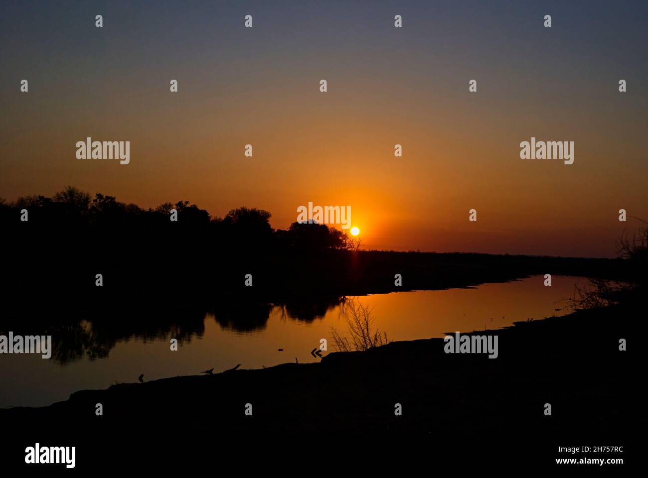 Beautiful moody and romantic sunset over a tranquil river in an african ...