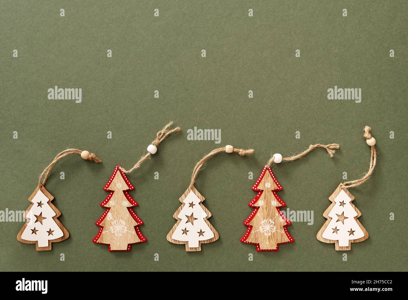 Green Christmas background with wooden tree ornaments and copy space