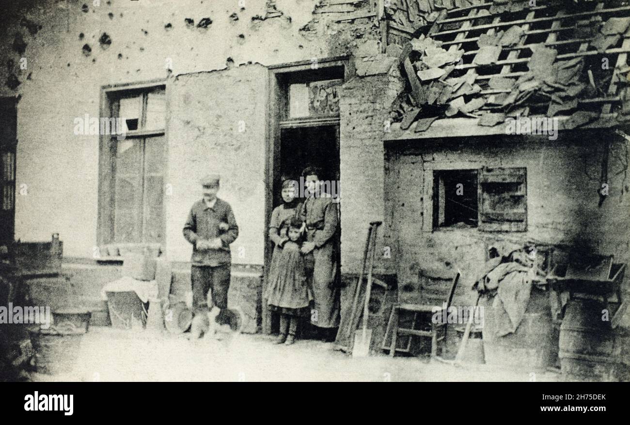 A historical view of French family standing outside their damaged house on Becourt Street in Albert, Somme, France, during the First World War. Stock Photo