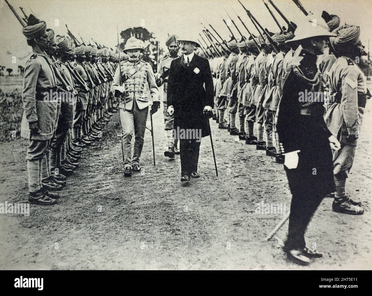 A historical view of British Colonial Indian Soldiers on parade being reviewed by British officers and a civilian administrator. C. 1914. Stock Photo