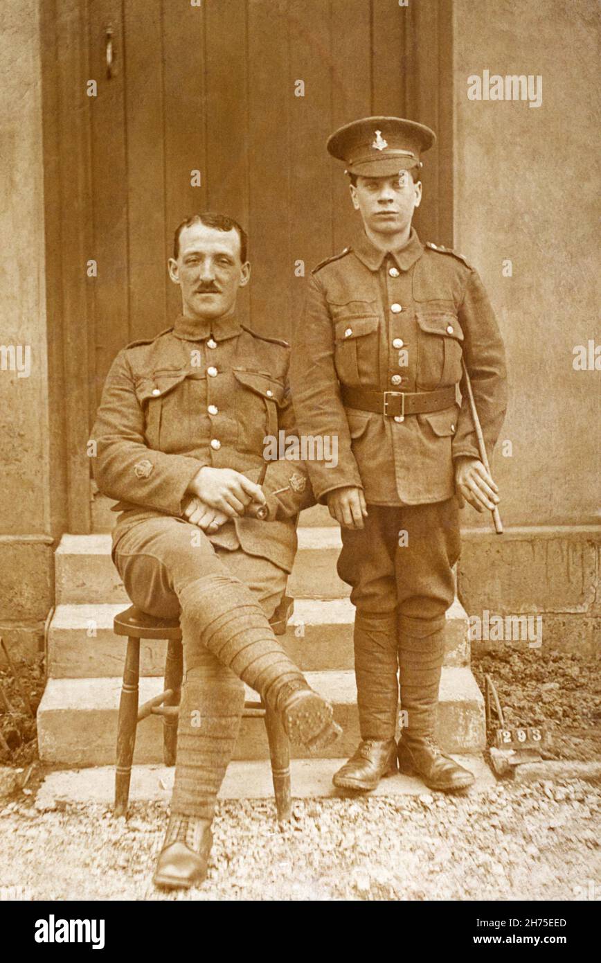 A First World War era picture of two British soldiers in The Princess of Wales's Own (Yorkshire Regiment), also known as the Green Howards. Seated is a warrent officer with a wounded stripe, standing is a very young private, possibly a boy soldier. Stock Photo