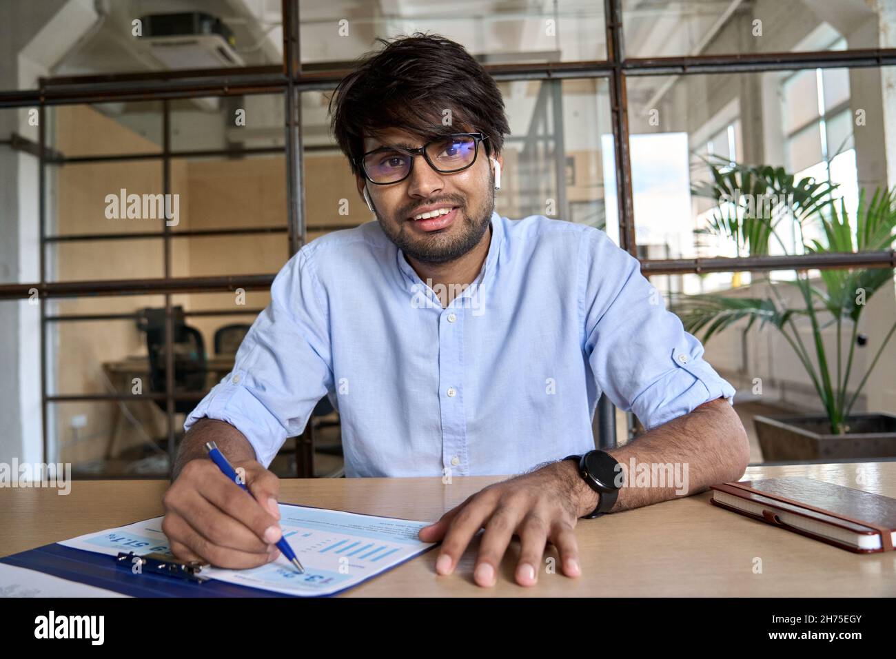 Young Indian financial advisor talking to web camera having virtual meeting. Stock Photo
