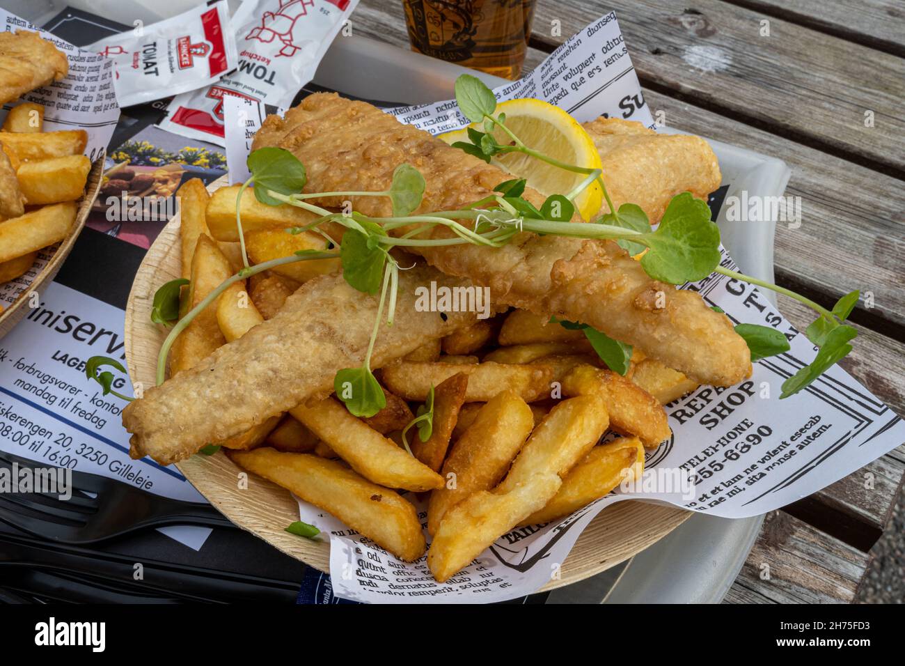 October 10, 2021 - Hundested, Denmark: A plate of delicious fish and chips. Business as usual in the restaurants in the marina Stock Photo
