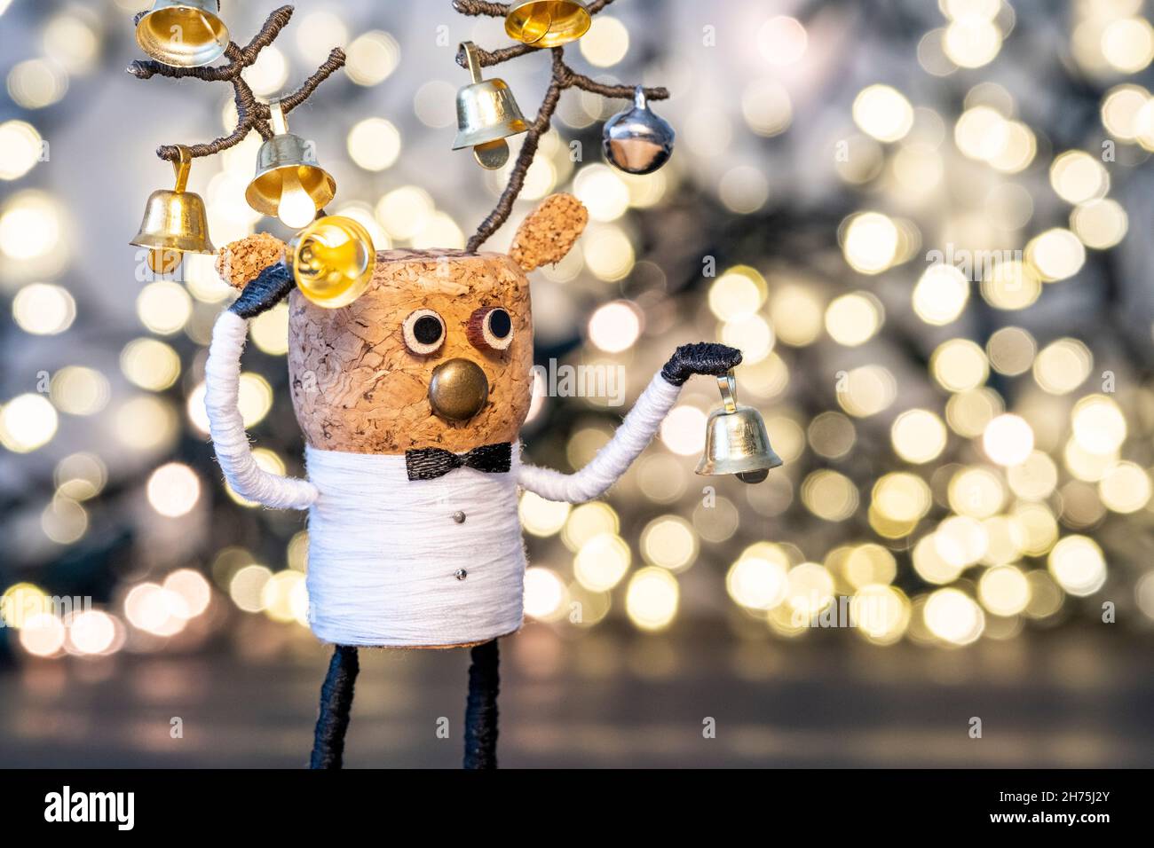 Elegant Cork deer with Christmas bells and bokeh background Gold Christmas home deco Creative Christmas Concept Festive cork Stock Photo