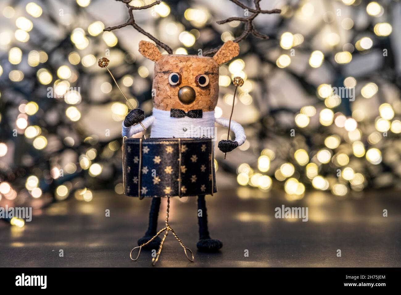Creative Christmas Concept Christmas lights with drumming cork deer, nostalgic Christmas ornament with gold tones Stock Photo