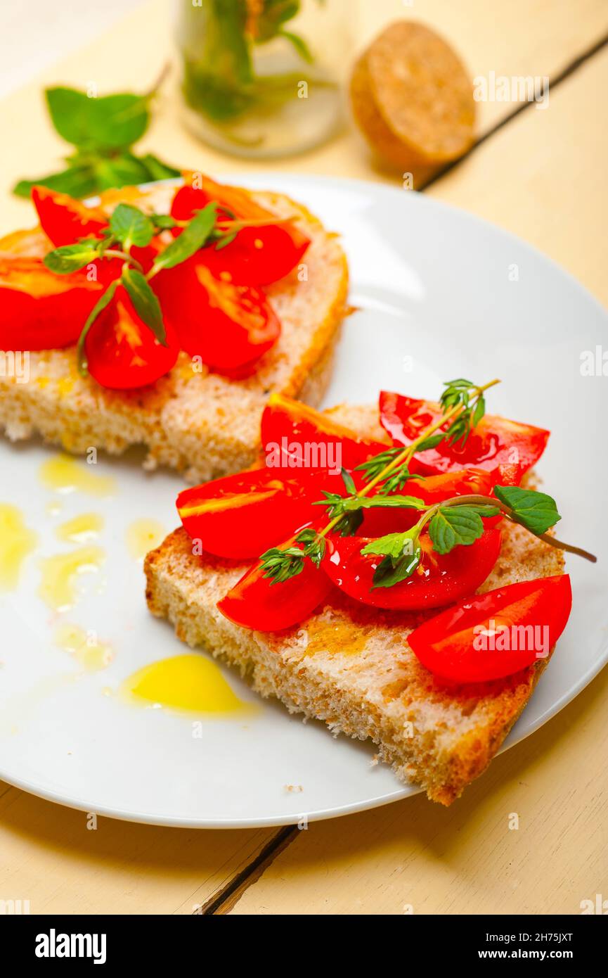 Italian tomato bruschetta with thyme and mint leaves Stock Photo