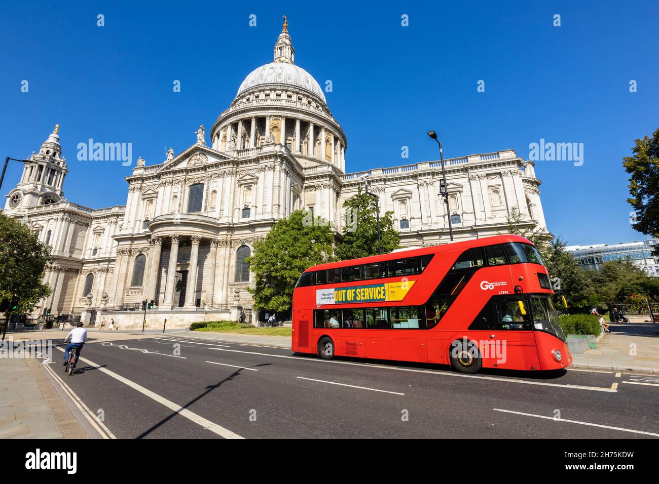 A double decker red London bus in front of the iconic St Paul's Cathedral by Sir Christopher Wren  in the City of London Stock Photo