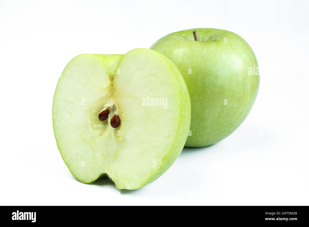 One whole and a half apple isolated on white background. Green fruit sliced Stock Photo