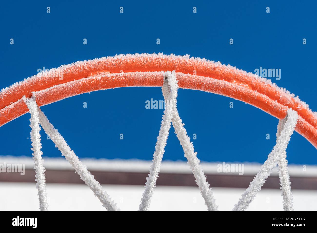 a close up of an orange frosted basketball hoop against blue sky Stock Photo