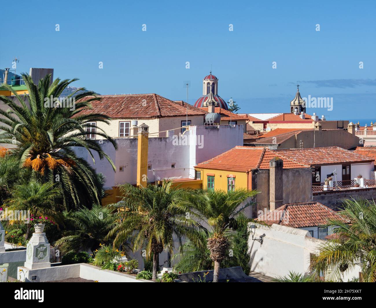 View over the red tiled roofs of the old town of La Orotava in the north of the Canary Island on Tenerife. In front of it the dark blue, calm Atlantic Stock Photo