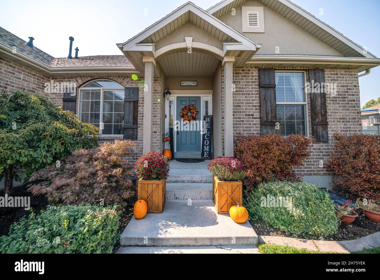 Inviting front entrance of a house with holloween ornaments at the front of the gray door Stock Photo
